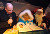 Weihnachtsmann und Mrchentante tragen sich im Beisein von Oberbrgermeister Roland Methling ins goldene Gstebuch der Hansestadt Rostock ein